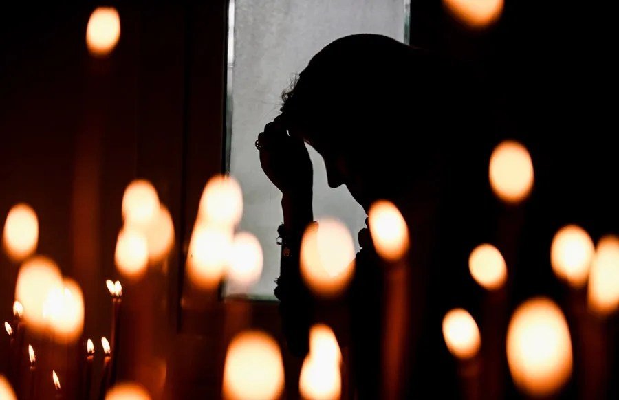 Una persona reza en una iglesia.