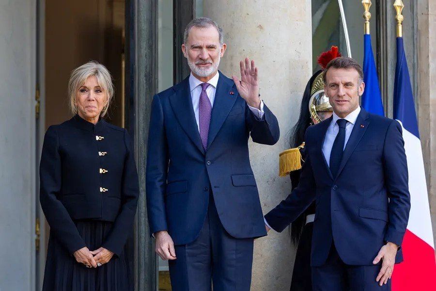 El presidente franc&eacute;s, Emmanuel Macron (d), y su esposa, Brigitte Macron (i), reciben al rey Felipe VI de Espa&ntilde;a (c) a su llegada al Palacio del El&iacute;seo