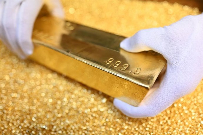 Archivo - FILED - 20 March 2023, Pforzheim: A gold bar weighing 12.5 kilograms is placed on gold granules at Agosi AG in Pforzheim. Photo: Uli Deck/dpa