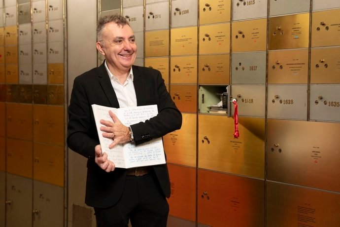 El escritor Manuel Vilas muestra uno de los veinte diarios personales legados al Cervantes antes de meterlo en la Caja de las Letras, tapando con su mano las p&aacute;ginas, cuyo contenido es secreto hasta 2051.