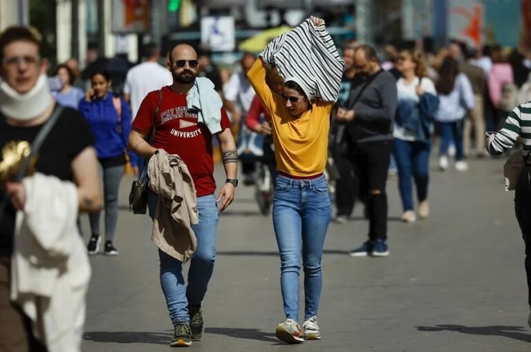 Una mujer se quita la sudadera.